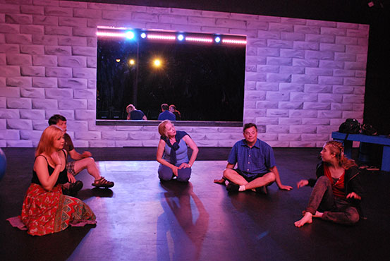 The cast of Theater Bartlesville's production of Circle Mirror Transformation sitting in a ring onstage.